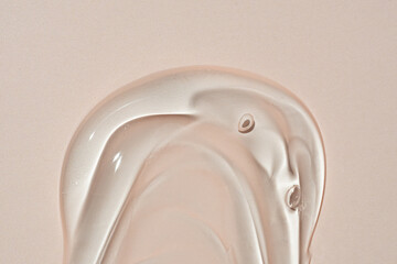 Liquid gel transparent cosmetic smudge texture on beige background