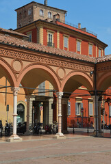 Obraz premium The Basilica of Santa Maria dei Servi stands along Strada Maggiore and is an example of Gothic architecture with the colorful buildings of Bologna around it.