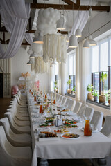 Set up and setting table. Trendy decor. Festive table with food and drinks, decor candles, flowers in restaurant. Delicious wedding reception. Arch decorated balloons. Birthday party celebration.