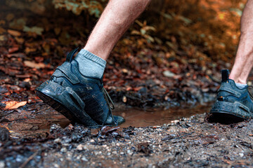 Fototapeta premium Trail runner stepping into the muddy puddle