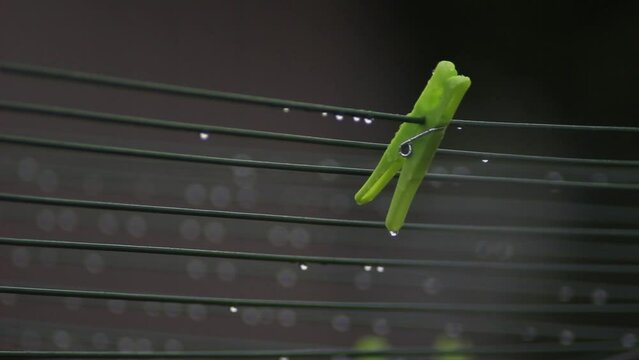 clothes peg with raindrops hanging on the wet washing line