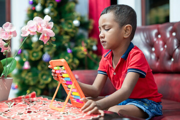 A boy is learning to count at home