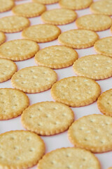 Salty crackers on a pink background vertical shot