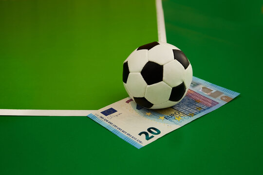 Soccer ball and 20 euro bill on green background, sports prediction, bookmaker betting, sports betting, betting on sports, money game