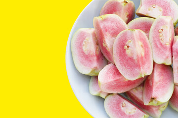 Fresh pink guava on yellow background.