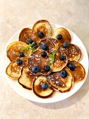 Pancakes with berries with sweet syrup on a white dish