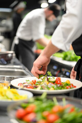 Naklejka premium Chef Prepares Fresh Salad Bar for Restaurant Guests