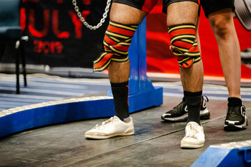 elastic wrap bandage on knees powerlifter athlete, powerlifting competition