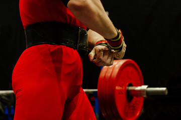 close-up athlete in red singlet on background bench press barbell