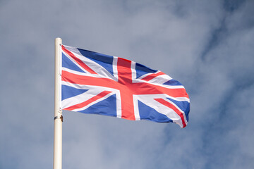 The English flag flies in the wind. It is also known as the union jack or union flag