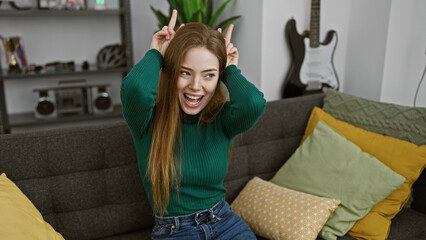 Obraz premium Playful young woman making funny faces in a cozy living room with modern decor