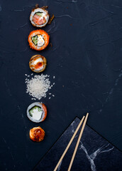 Sushi composition on black background. The Art of Japanese Cuisine. Food photography for menu and sushi bar decoration