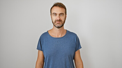 Portrait of a handsome middle-aged hispanic man with a beard, wearing a casual t-shirt against a...