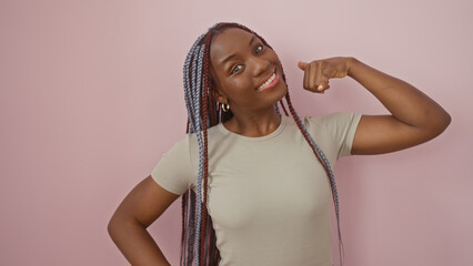 African american woman with braids mimicking a phone call against a pink background