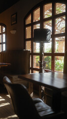A cozy restaurant interior with ambient lighting featuring a leather booth beside a window with outdoor views.