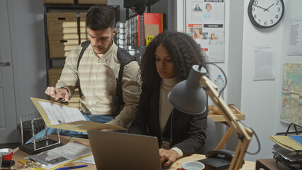 Woman and man police detectives working together in a cluttered office, analyzing documents and...