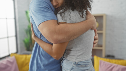 A loving couple embraces warmly in a cozy living room, depicting affection and a comfortable home environment.