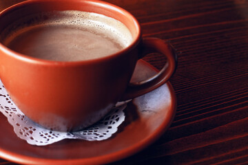 Fresh Americano coffee with milk in traditional  brown clay cup  on the wooden table