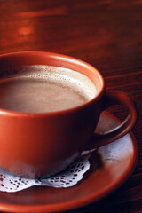 Fresh Americano coffee with milk in traditional  brown clay cup  on the wooden table