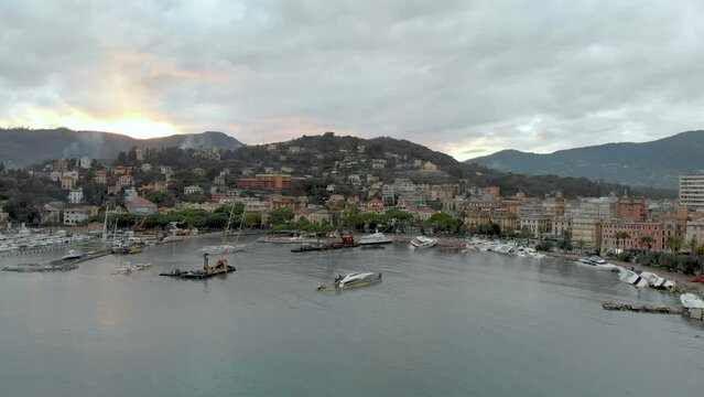 Aerial view of Carlo Riva Marina destroyed by powerful storm. Extreme disaster aftermath, sunken yachts and boats, piles of debris, catastrophic weather events damage. Rapallo, Italy.
