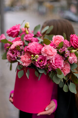 Girl in a black jacket with a bouquet of red roses
