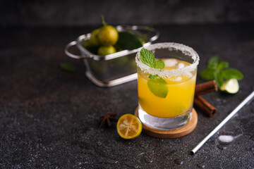 Fresh summer orange mojito with tangerine orange, mint and ice on black background