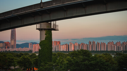 Scenery of Hangang Park with trees, red buildings and overpasses at sunset