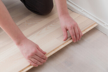 Professional worker installing new parquet flooring indoors, closeup
