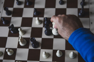 Close up of hand holding chess on chess board