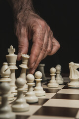 Close up of hand holding chess on chess board