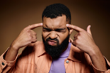 Stylish African American man with a beard in a bold purple shirt strikes a strong pose.
