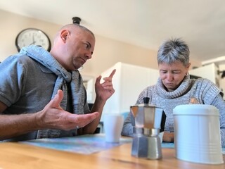 Happy couple having breakfast together.Man and woman having breakfast and talking.Young adult couple eating first meal together at home.Having breakfast and talking about economic or work problems.