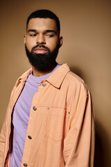 Handsome African American man with beard standing in front of colorful backdrop.