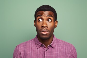 Obraz premium A man with a surprised expression on his face is wearing a purple shirt