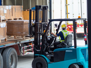 Workers drive forklifts and move products to be stored in warehouses. Lifting cargo on truck concept of logistics.
