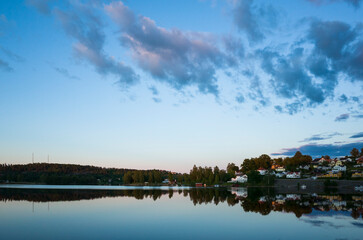 Bengtsfors city by the Lelång lake at Swedish summer night, Nordic town reflecting in calm water...