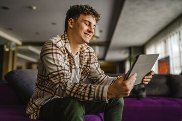 Young adult boy use digital tablet for online chat or explore internet