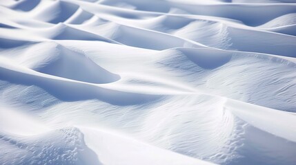 Close-up of snow drifts, bright daylight, smooth and undulating with subtle shadows. 