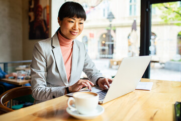 Focused businesswoman working on laptop in cafe