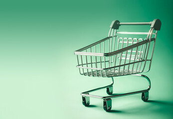 Empty supermarket trolley on green background