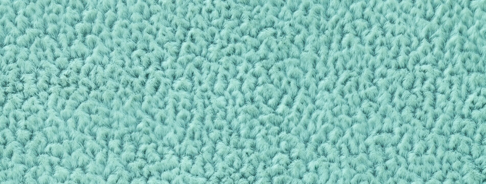 Texture of cyan fluffy woolen textile background from soft fleecy material, macro. Structure of turquoise fabric