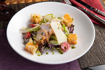 Salad with chicken fillet and cheese in a plate.