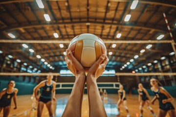 Close-up of hands holding volleyball in gymnasium with players in background, capturing the intensity and focus moments before the match begins. - Powered by Adobe