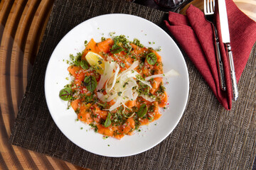 Salmon carpaccio in a plate.