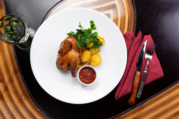 Half a fried chicken and a baked potato in a bowl.