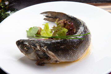 Cooked sea bass in a plate.