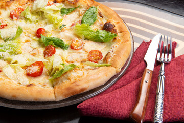 Pizza with tomato, lettuce and cheese in a plate.