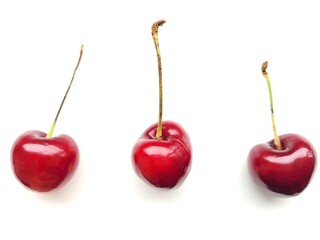 Three juicy cherries on a white background.