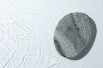 Presentation of product. Stone podium in water on white background, top view. Space for text
