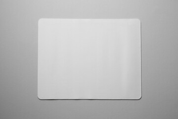 One mouse pad on grey background, top view. Space for text